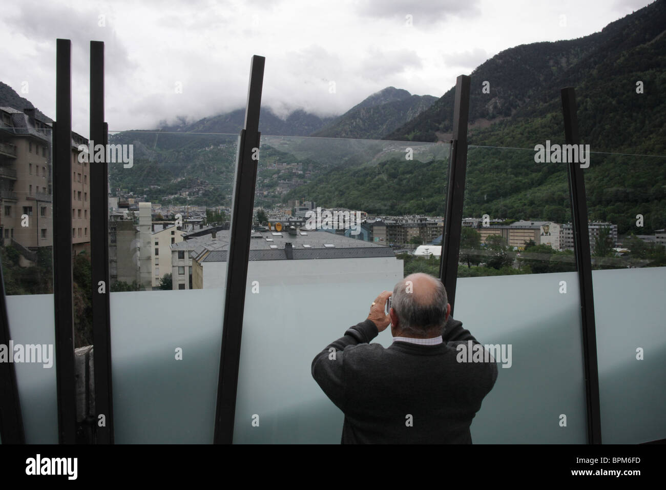 A tourist taking pictures in centre of the capital city of Andorra La Vella in Andorra viewed from the Congress Centre Stock Photo