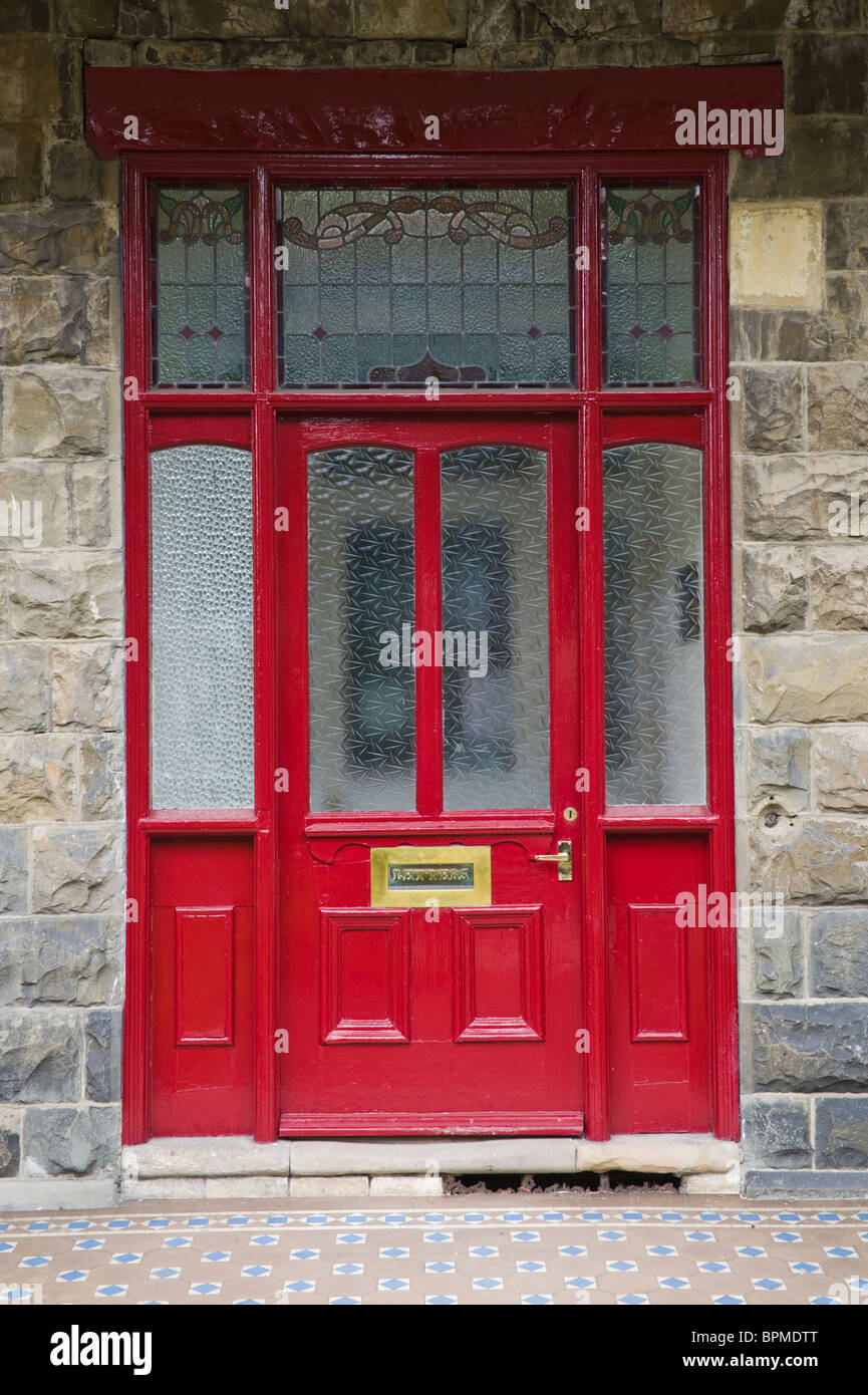 Victorian paneled and glazed red painted front door and framing of stone built house in Llandrindod Wells Powys Mid Wales UK Stock Photo