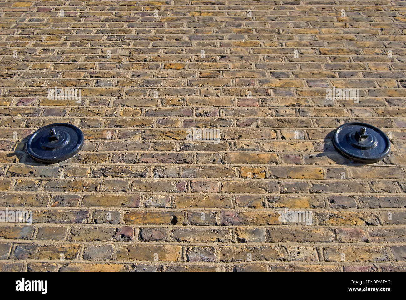 two wall braces set at equal height into a brick wall, in twickenham