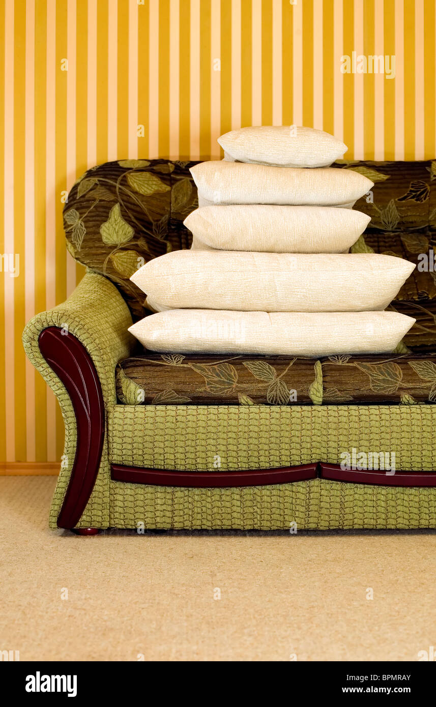 Many Pillows On Green Couch With Yellow Background Stock Photo