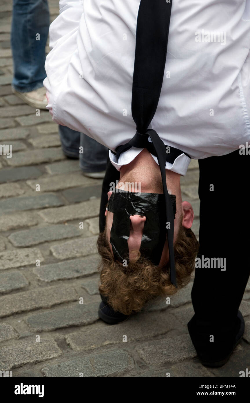 Man hanging upside down with tape stuck to his face, promoting a Fringe show in the Edinburgh