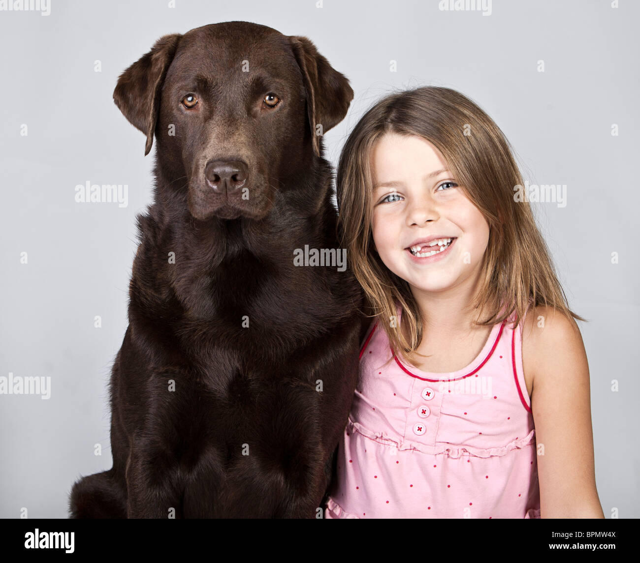 Cute 6 yr old girl with her Chocolate Labrador Stock Photo
