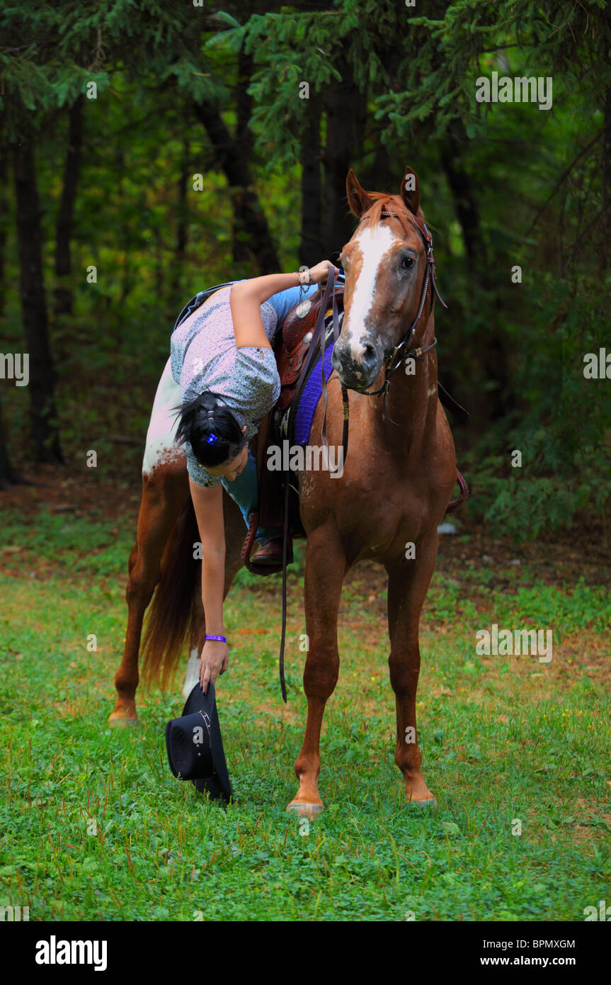 Сowgirl on horse at dusk Stock Photo