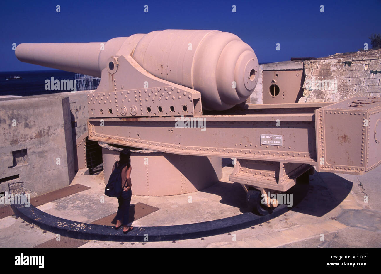 Malta, a tourist takes in the mammoth 100-ton Armstrong Gun, the largest gun ever made, at Fort Rinella. Stock Photo