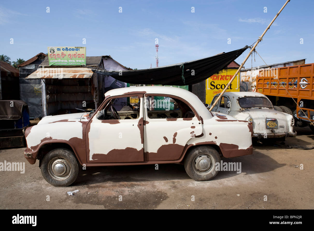 Old white Indian Ambassador car parked in a garage near the bus station in Puri, Orissa, India. Stock Photo
