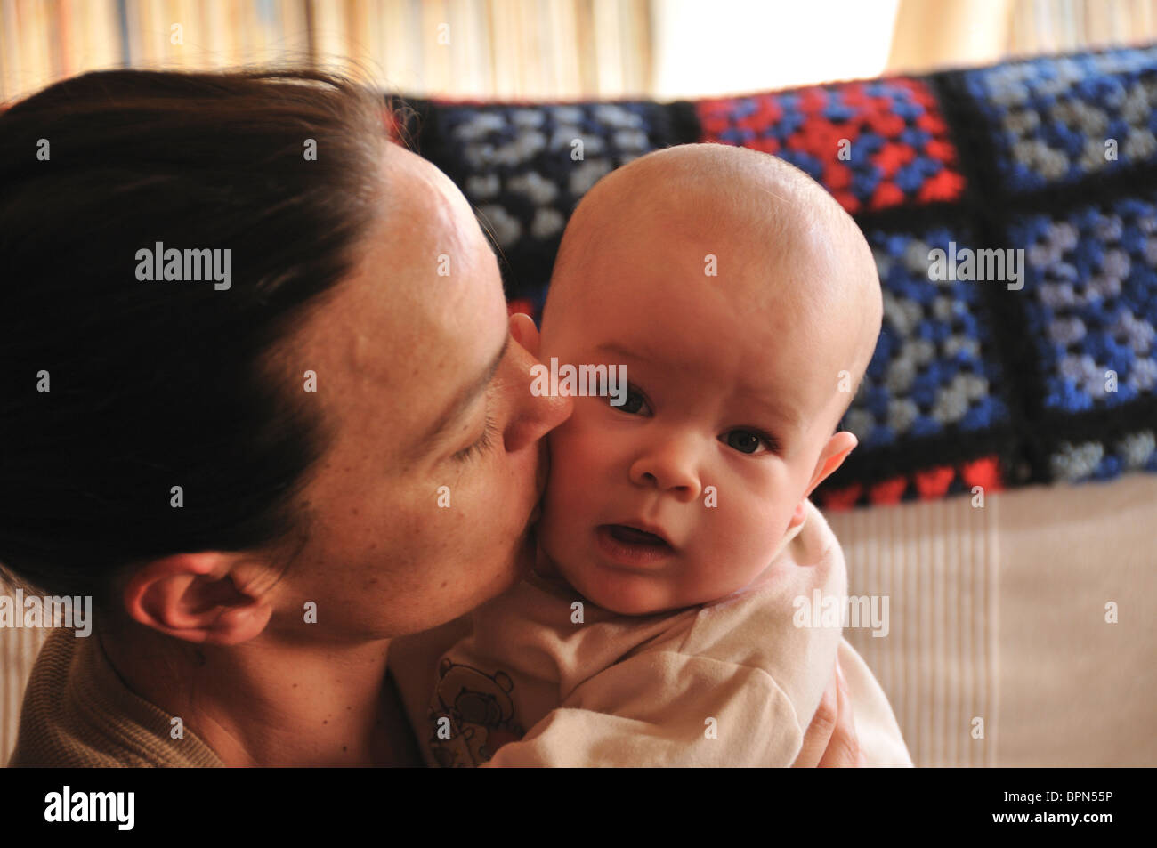 Mother kissing her four months old baby Stock Photo