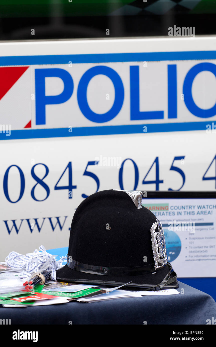 Police helmet with police sign writing on van and partial phone number Stock Photo