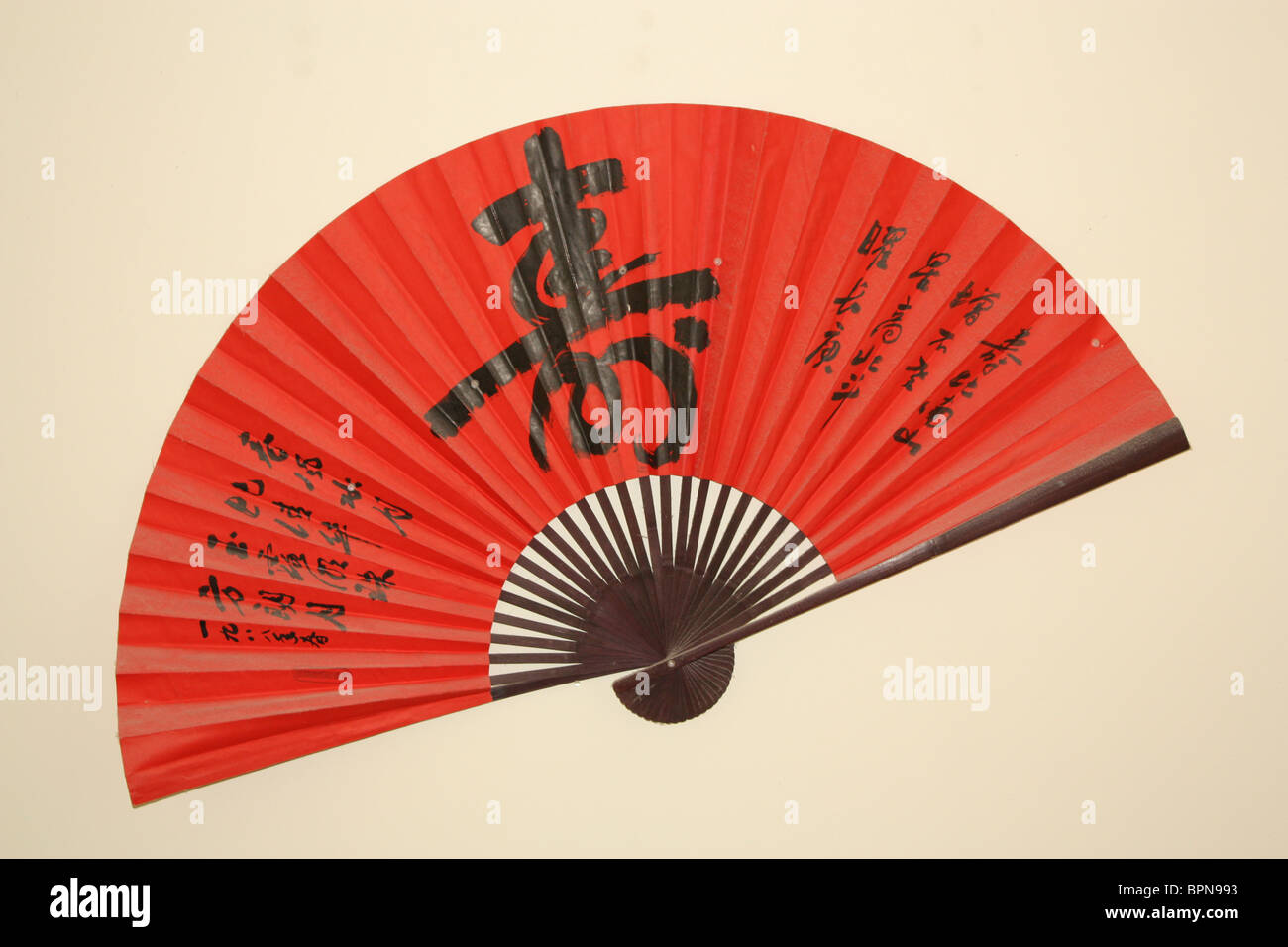 red chinese fan hanging on wall Stock Photo