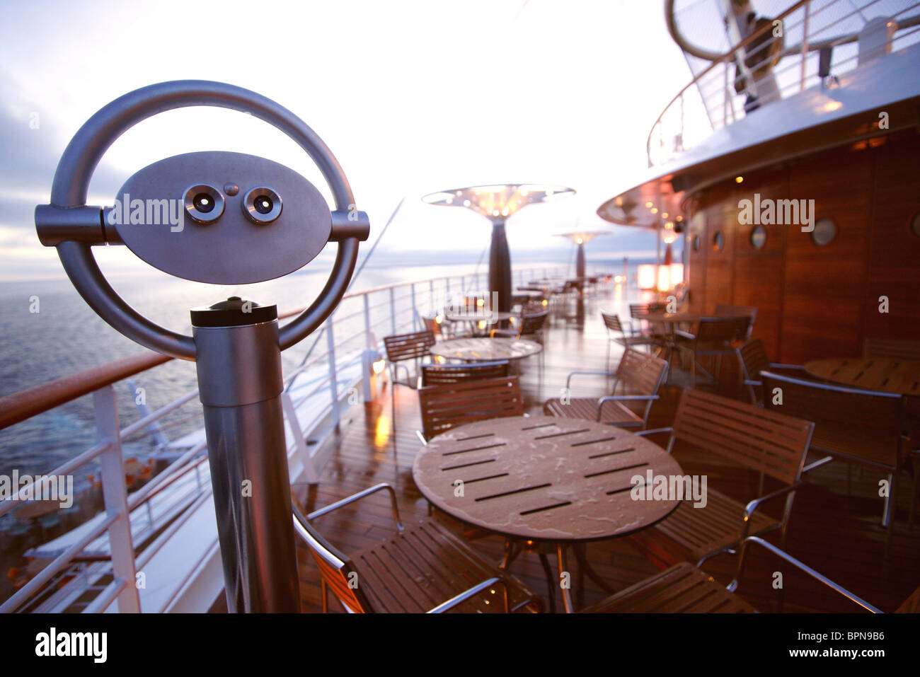 Binoculars, tables and chairs on AIDA Bella cruiser in the evening, Mediterranean Sea Stock Photo