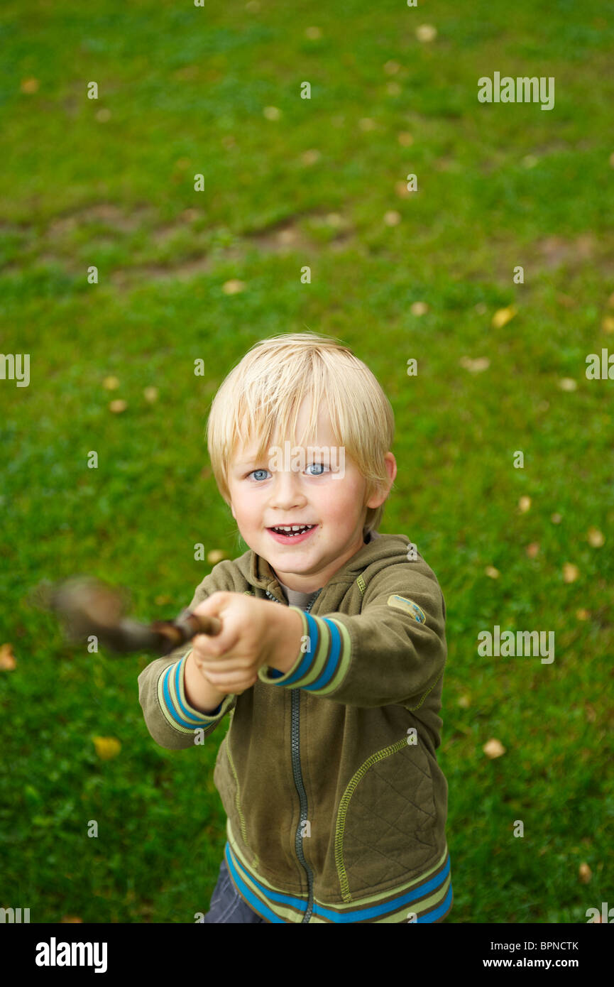 Boy playing with branch swords Stock Photo