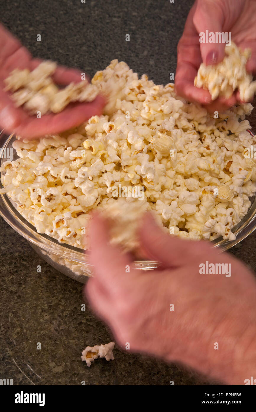 People Snacking on Bowl of Popcorn Stock Photo