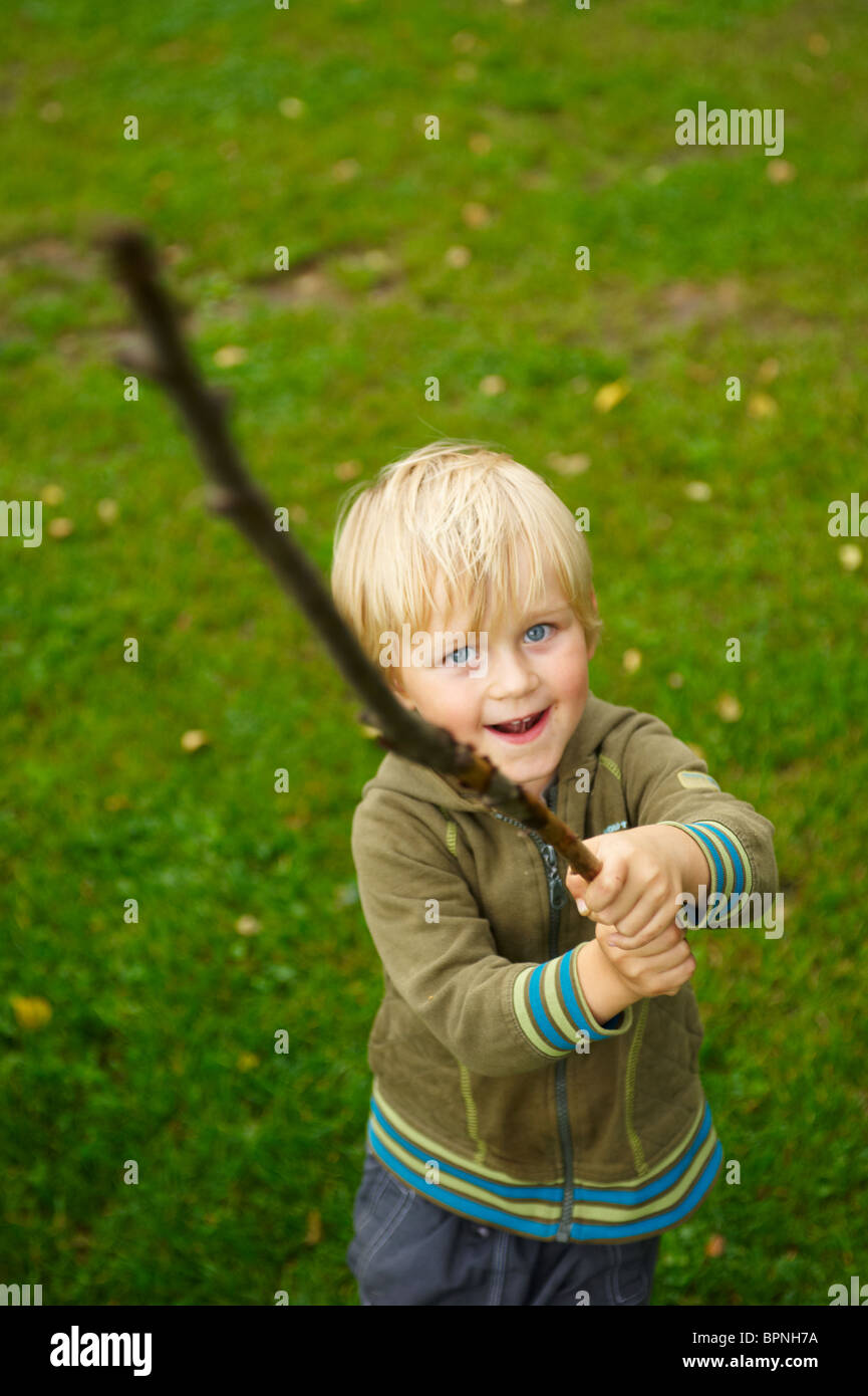 Boy playing with branch swords Stock Photo