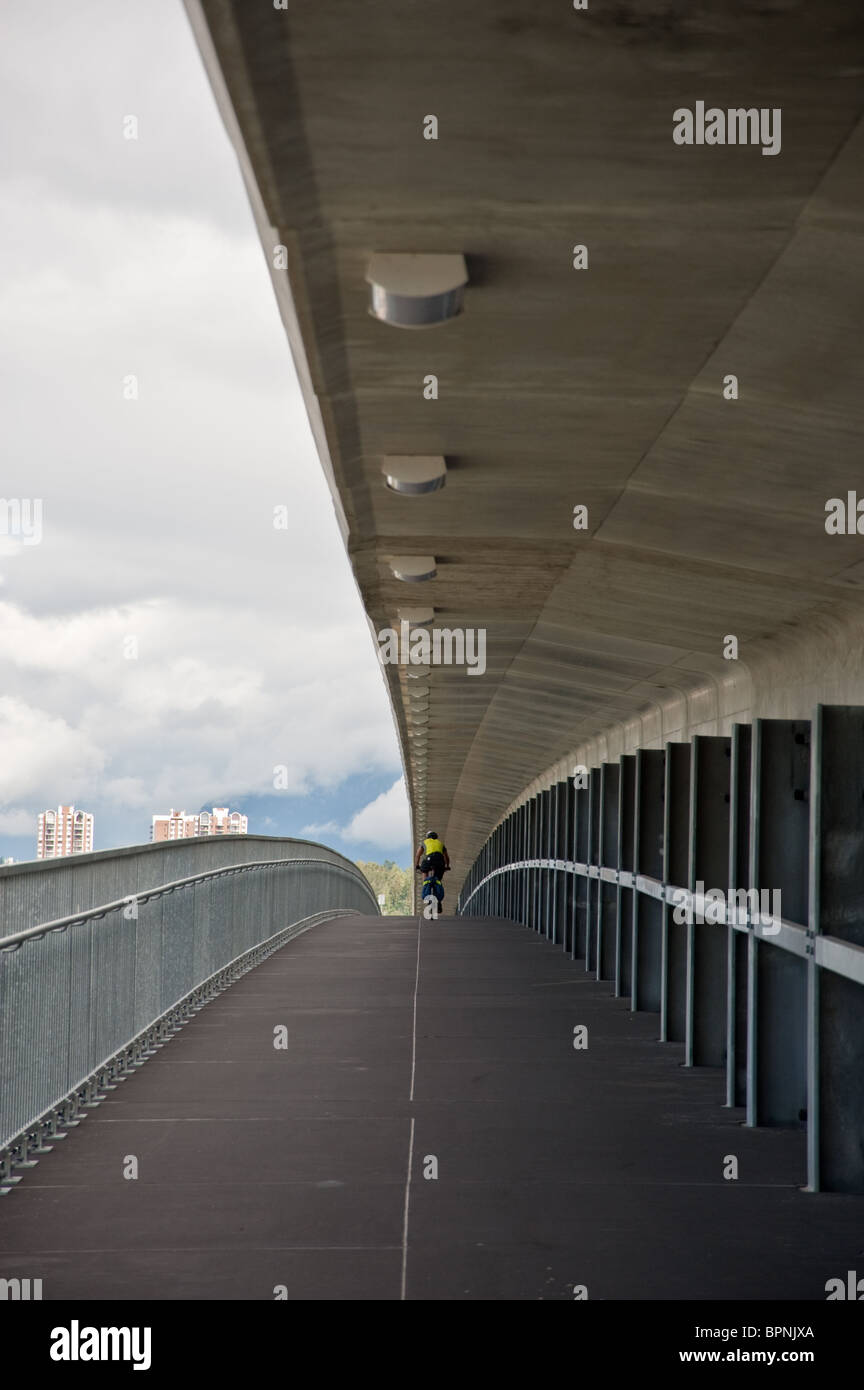 A bicyclist riding on a metro bridge over the Fraser river in Vancouver, BC Stock Photo