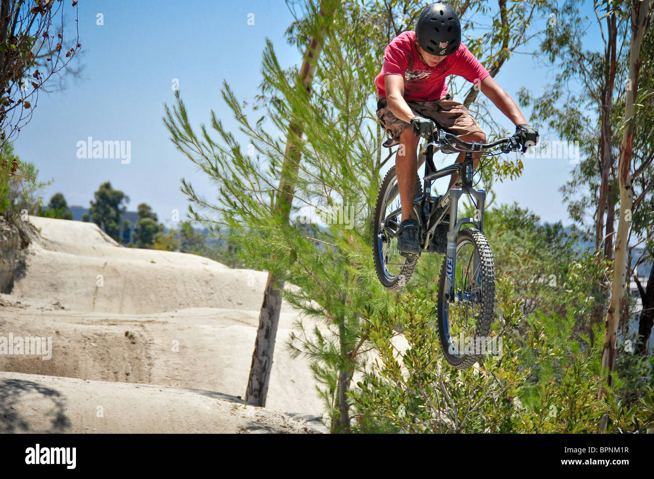 riding bmx and mountain bikes at the Oakley dirt jump track Stock Photo