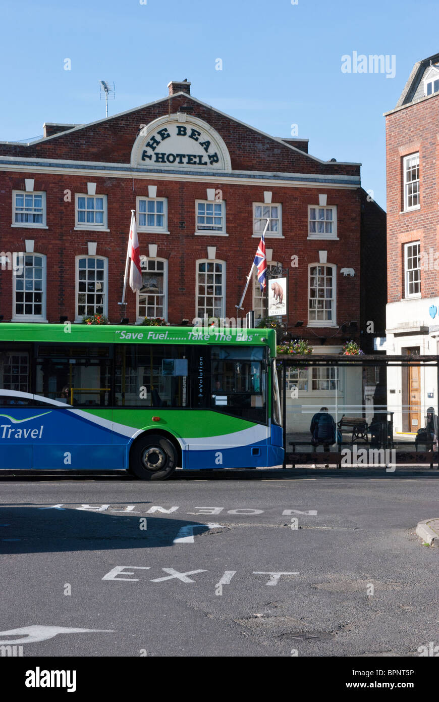 A bus belonging to Thames Travel sits in front of the Bear Hotel in the historic market place in Wantage, Oxfordshire,England Stock Photo