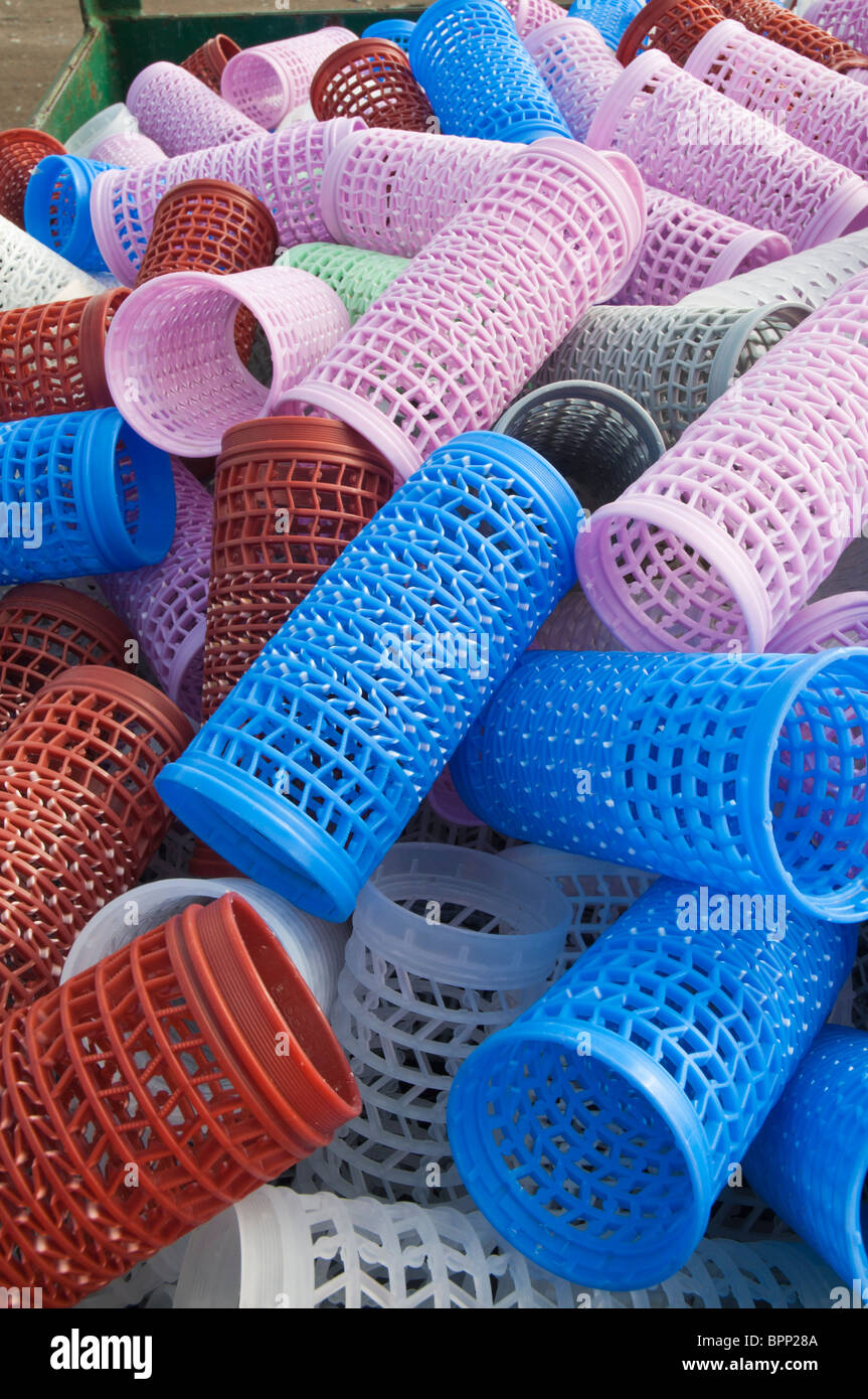 Plastic hair curlers stockpiled for recycling at a recycling plant Stock Photo