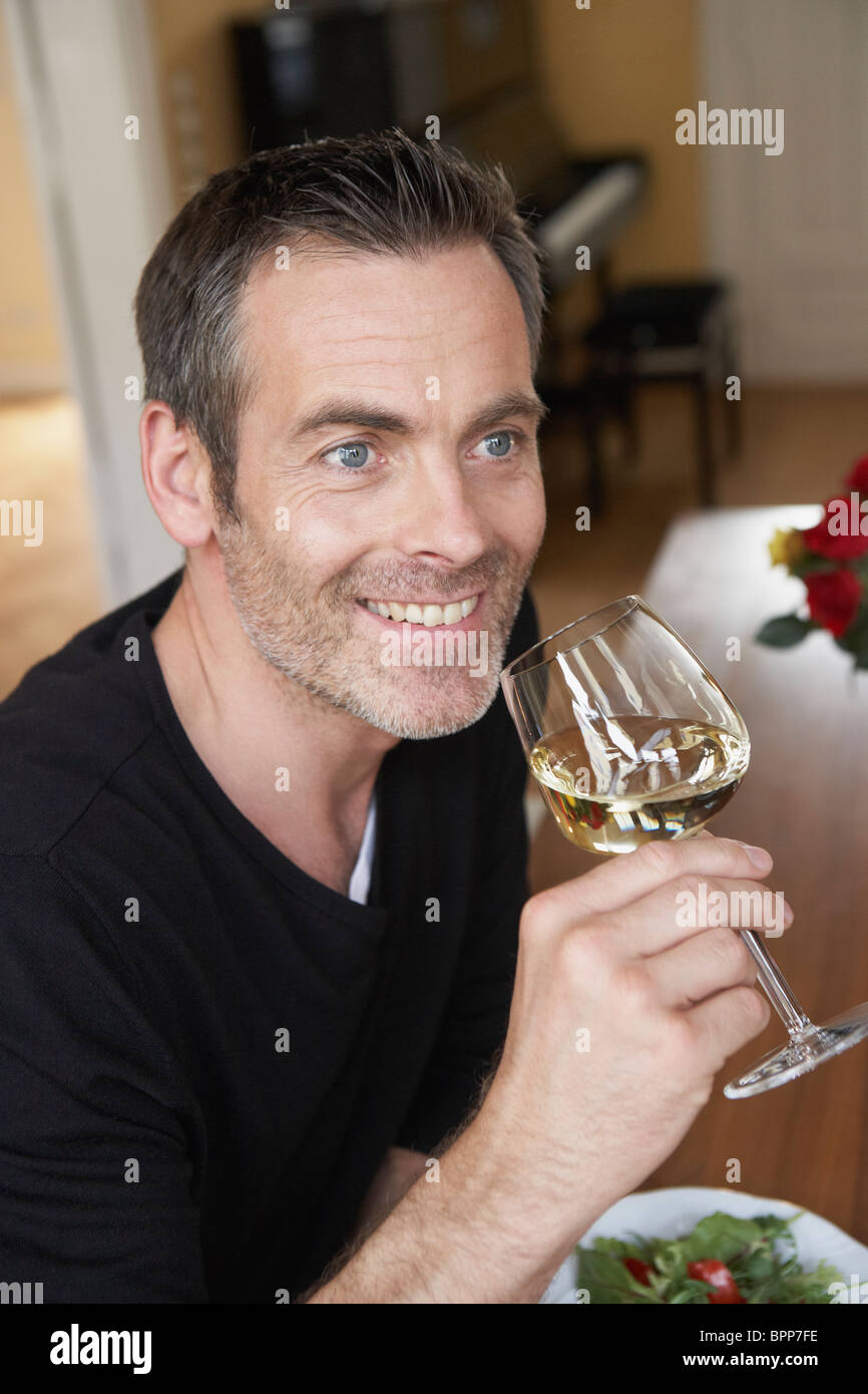 Man sipping on white wine Stock Photo