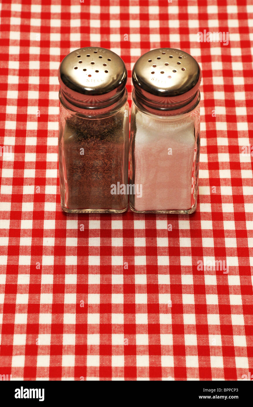 Salt and pepper shakers on red gingham tablecloth. Stock Photo