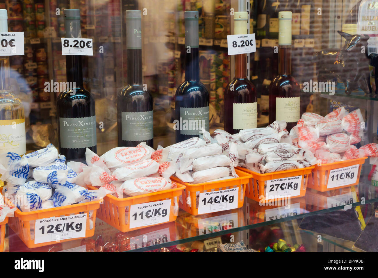 Malaga, Costa del Sol, Spain. Food shop window displaying local delicacies including polvorones and fortified wines Stock Photo