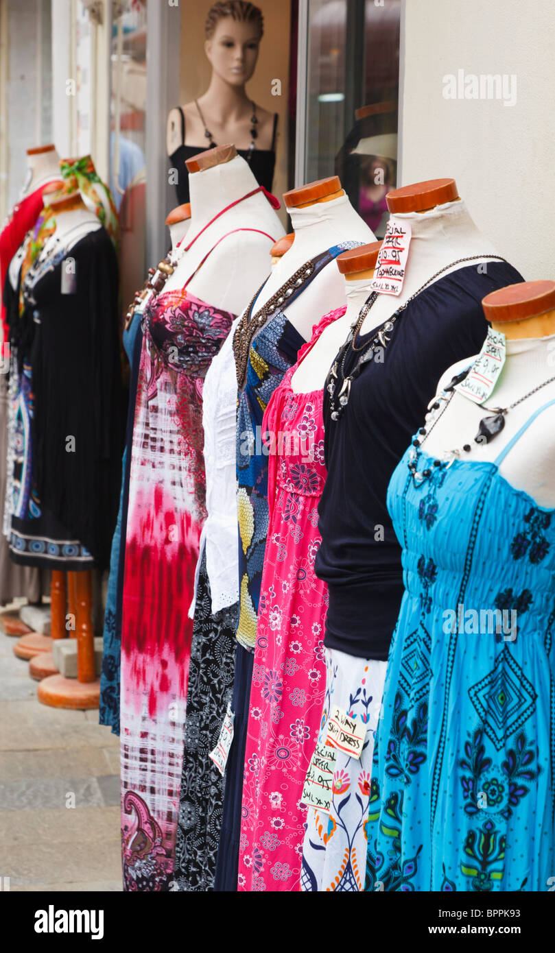 Stands of mannequins modelling dresses on street outside clothing shop Stock Photo