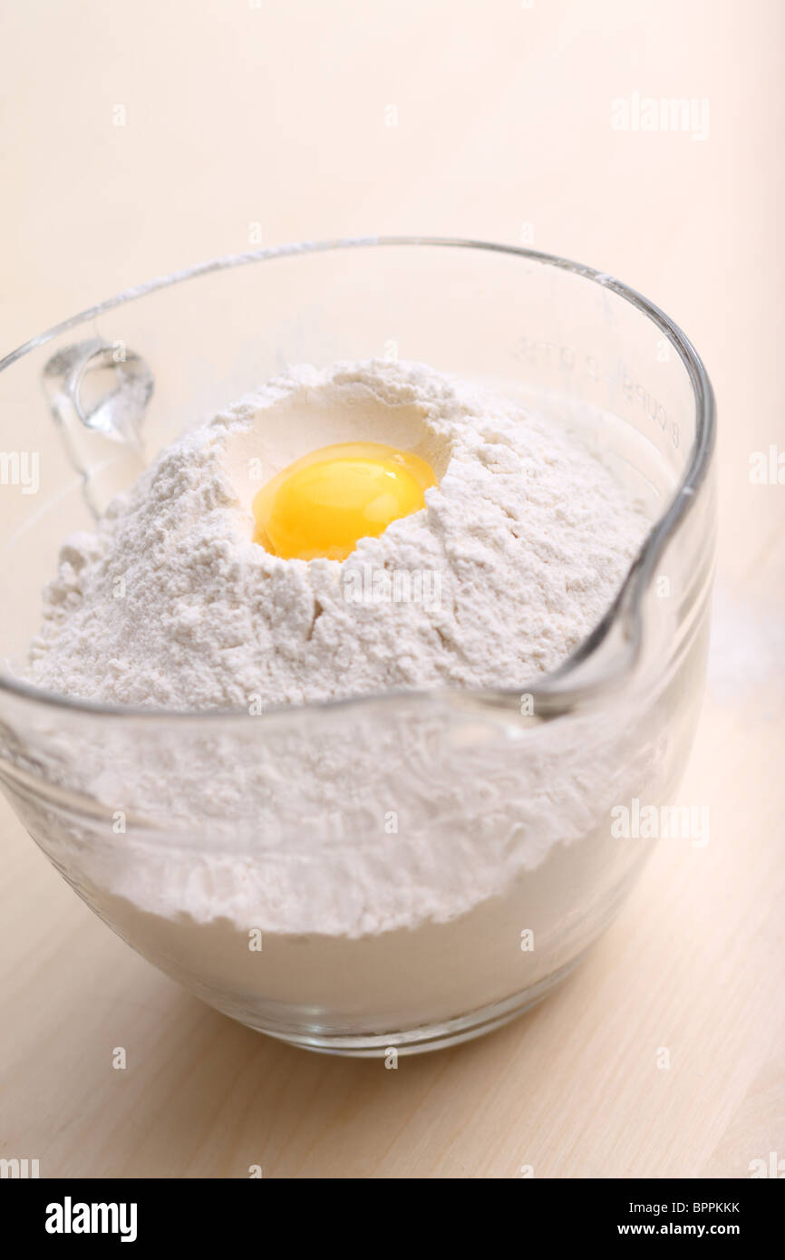 Bowl of flour with egg Stock Photo