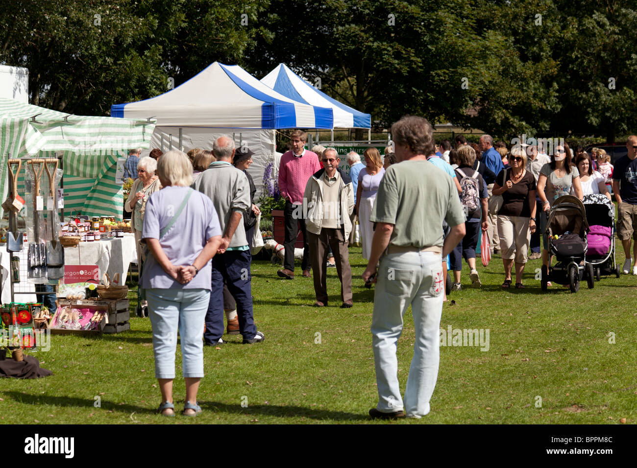 visitors wandering amonst the stalls a a country fair flower show Stock Photo