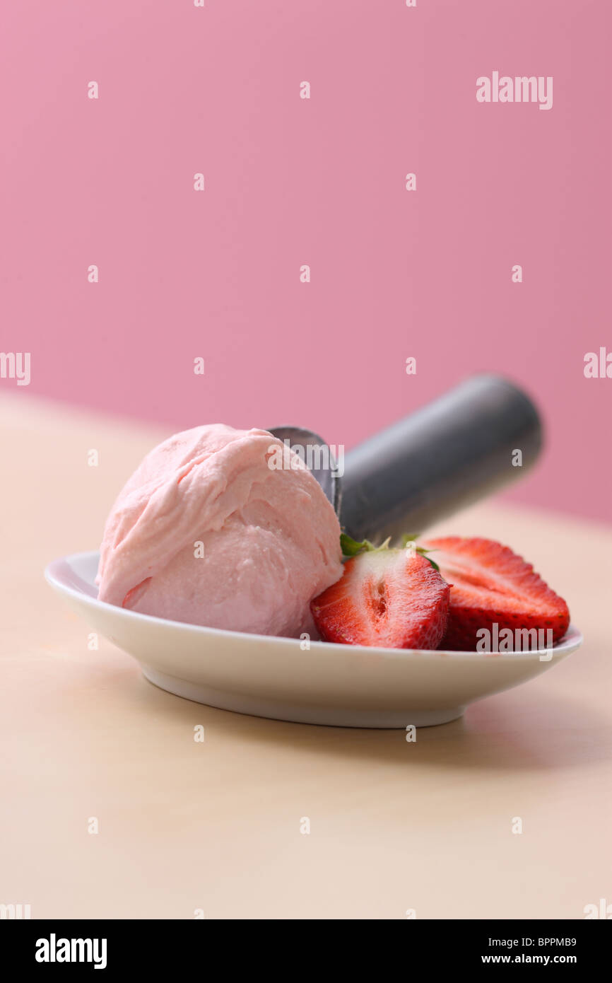 Scoop of strawberry ice cream and fresh strawberries Stock Photo