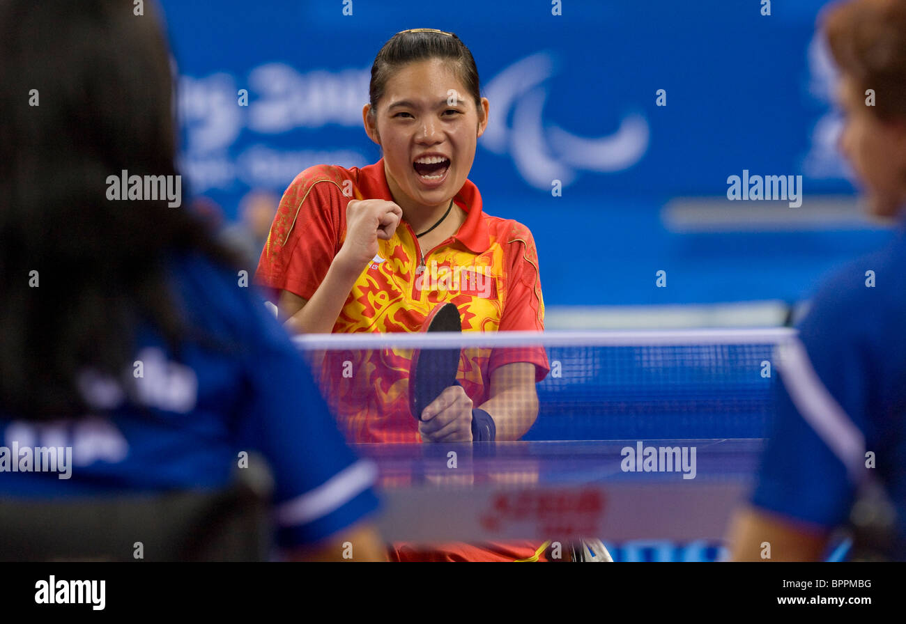 Female wheelchair table tennis player reacts after winning a point in