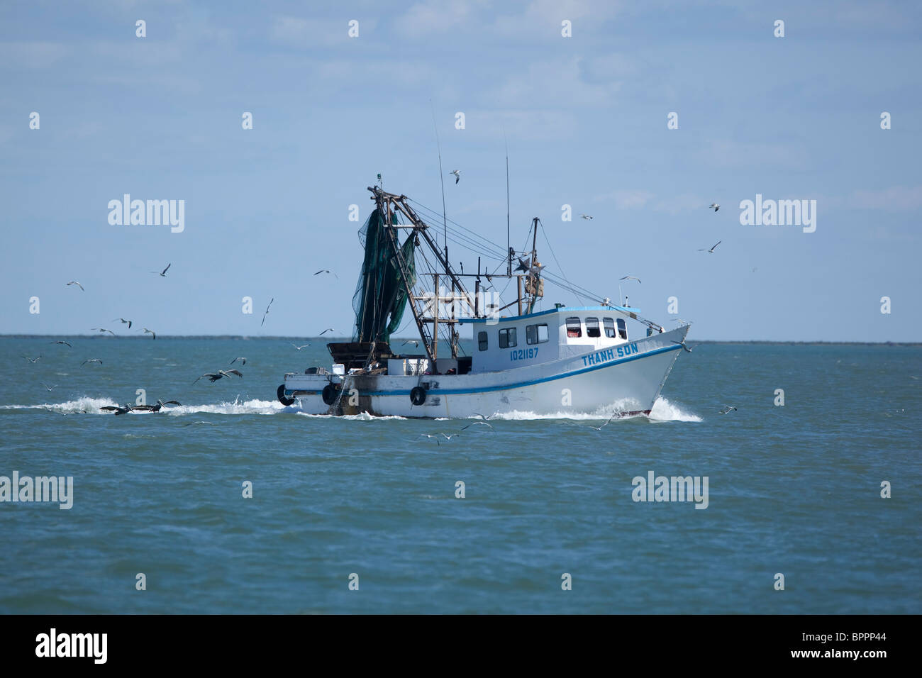 Shrimp boat with Vietnamese name heads towards the Gulf of Mexico near Port Aransas, Texas, USA Stock Photo