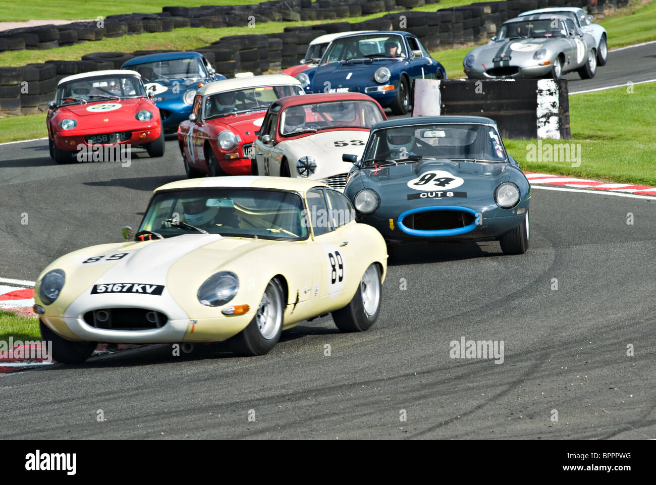 Two E Type Jaguar Lead Other Race Cars Through Brittens at Oulton Park Motor Racing Circuit Cheshire England United Kingdom UK Stock Photo