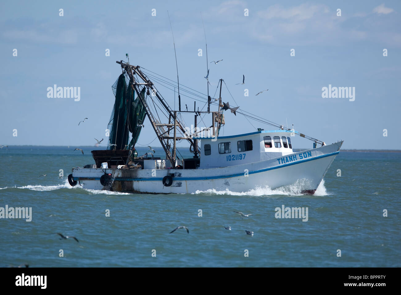 Shrimp boat with Vietnamese name heads towards the Gulf of Mexico near Port Aransas, Texas, USA Stock Photo