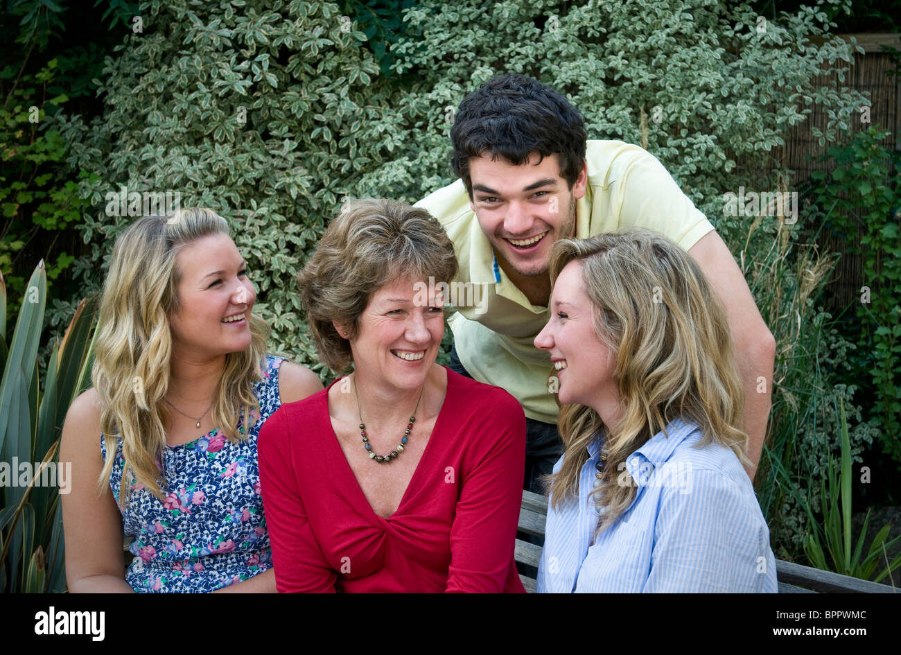Happy family of four outside in their home garden Stock Photo