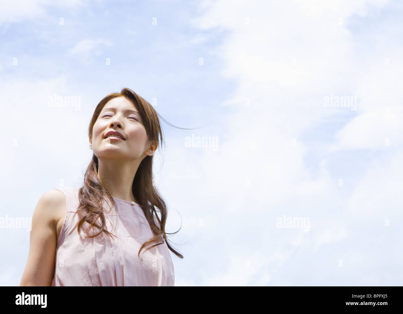 Young woman under blue sky Stock Photo - Alamy