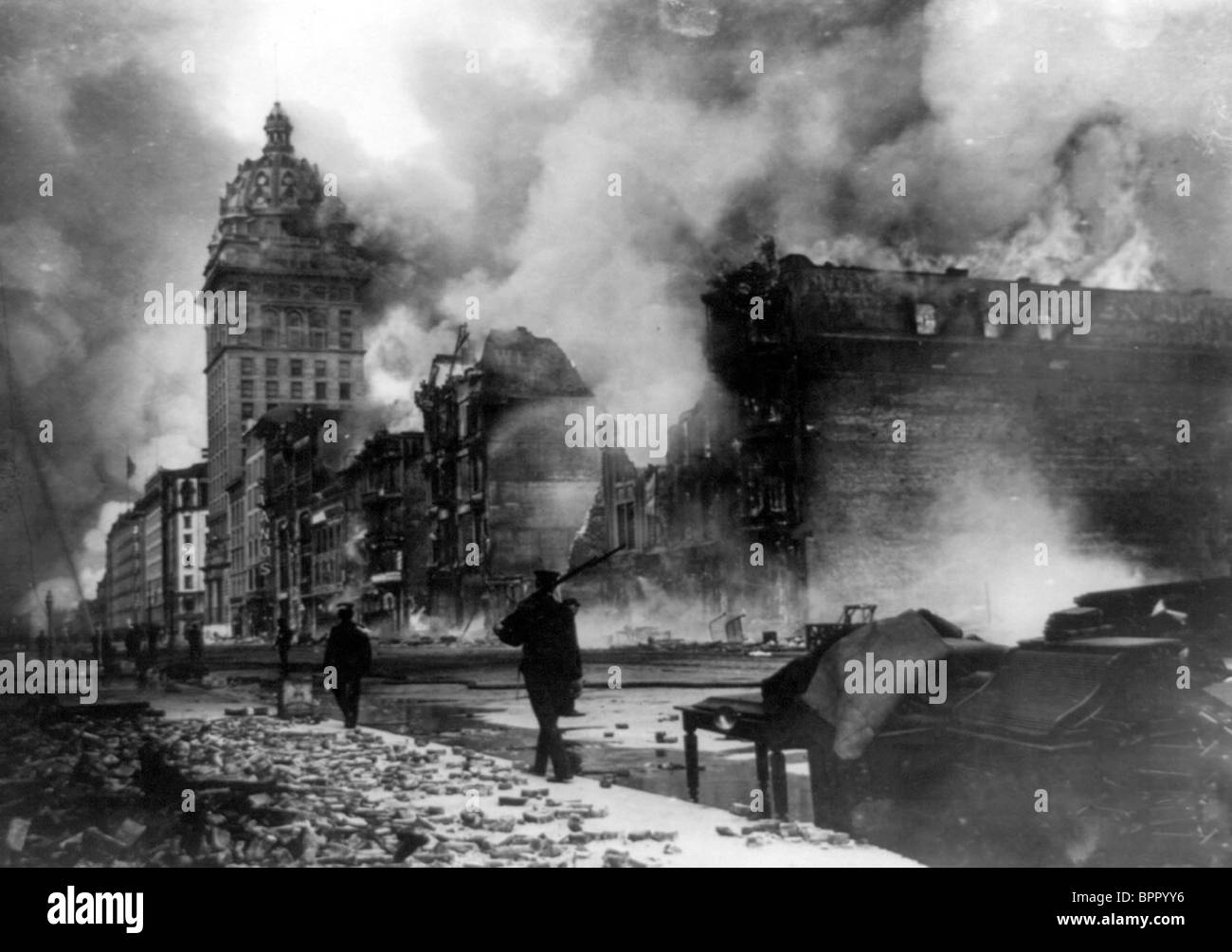 Fire on Market Street - View of street in San Francisco, California, earthquake aftermath with man patrolling with gun Stock Photo