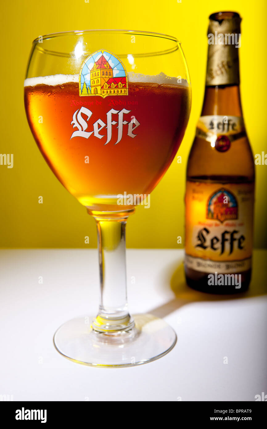 A glass of Leffe Belgian beer shot in the studio against an amber