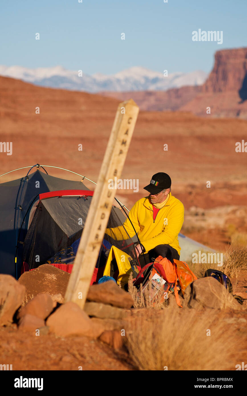 A man setting up camp in the desert. Stock Photo