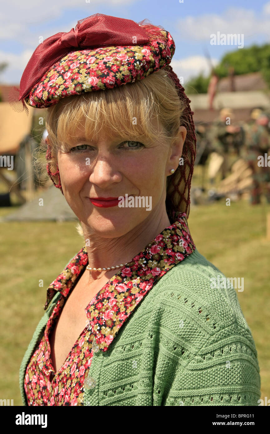 An attractive blonde woman civilian wearing authentic WW2 clothing during a reenactment weekend Stock Photo