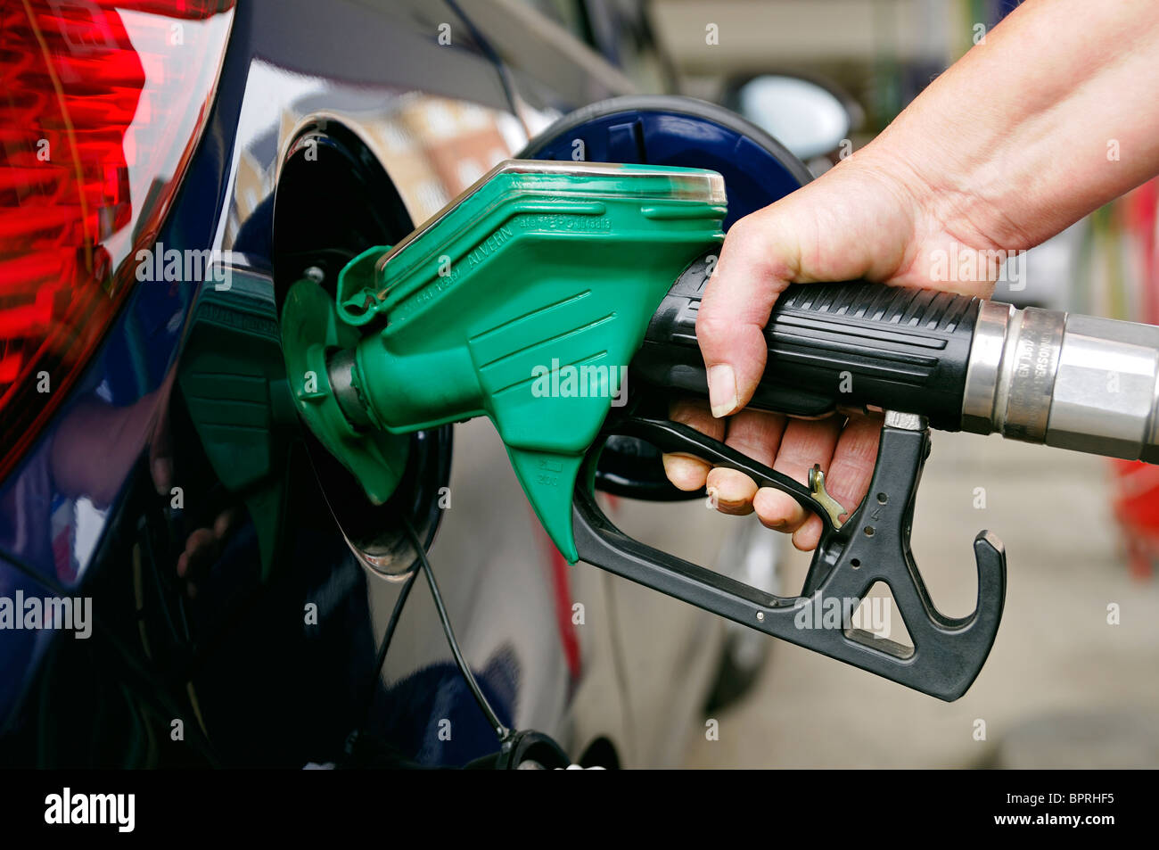 Woman Filling a Car with Unleaded Petrol, UK. Stock Photo