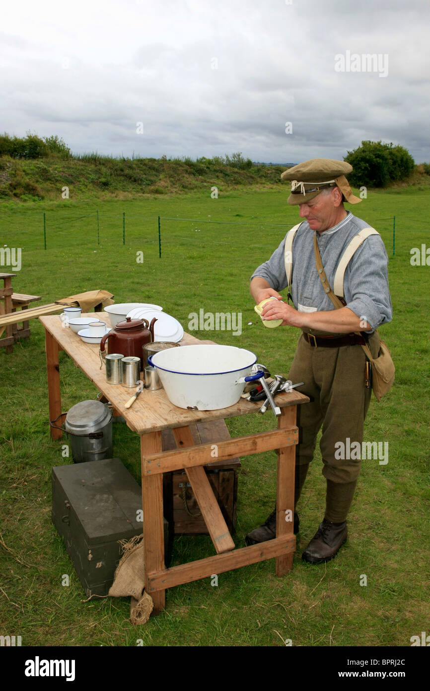 Male reenactment group soldier wearing the uniform of a WW1British Army infantryman taking care of the washing up Stock Photo