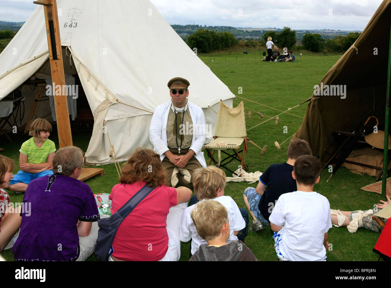 Children surround a man dressed as a WW1 doctor as he talks about life in the trenches Stock Photo