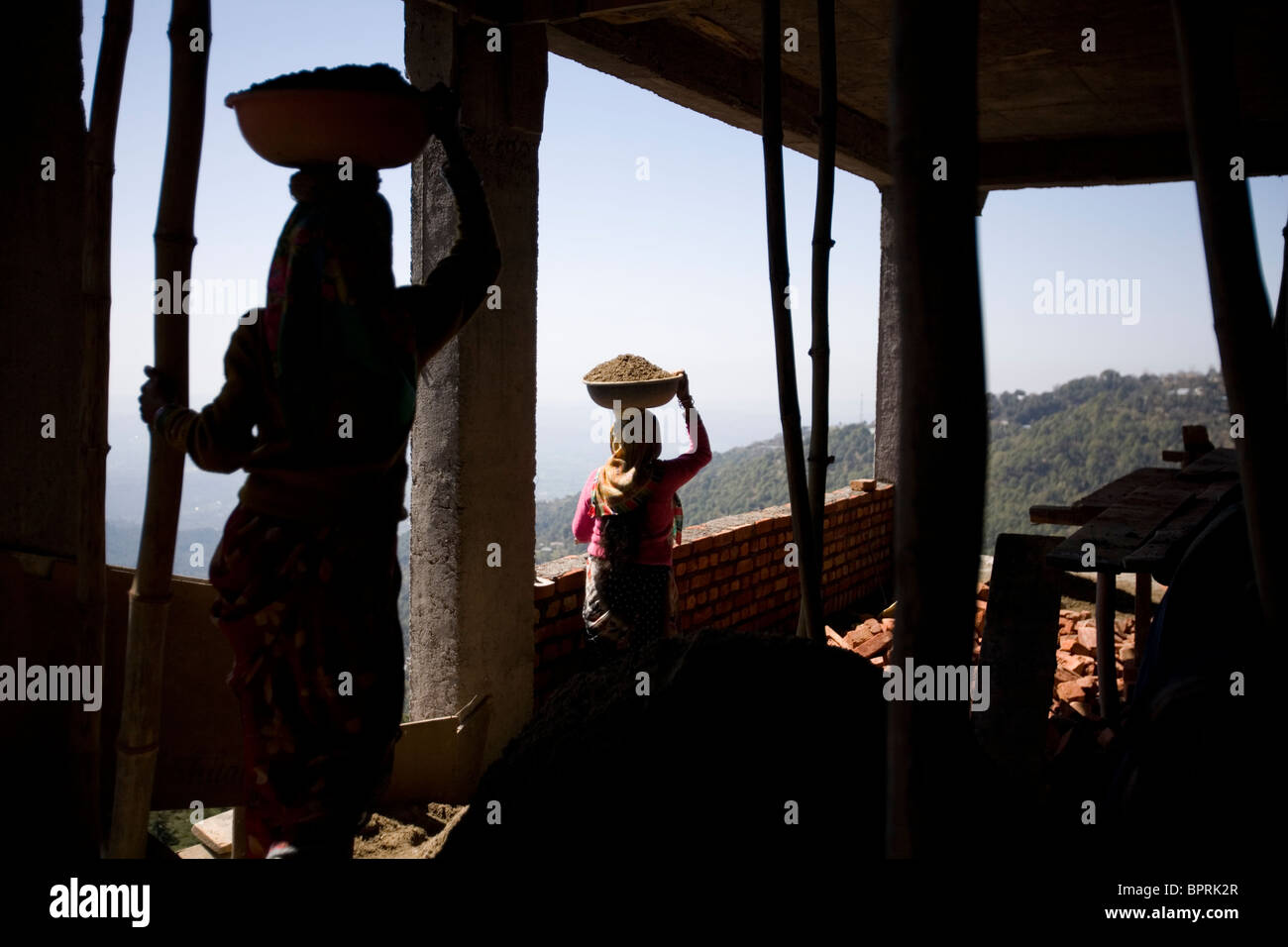 Woman carrying baskets of building material Dharamsala, Himachal Pradesh, India. Stock Photo