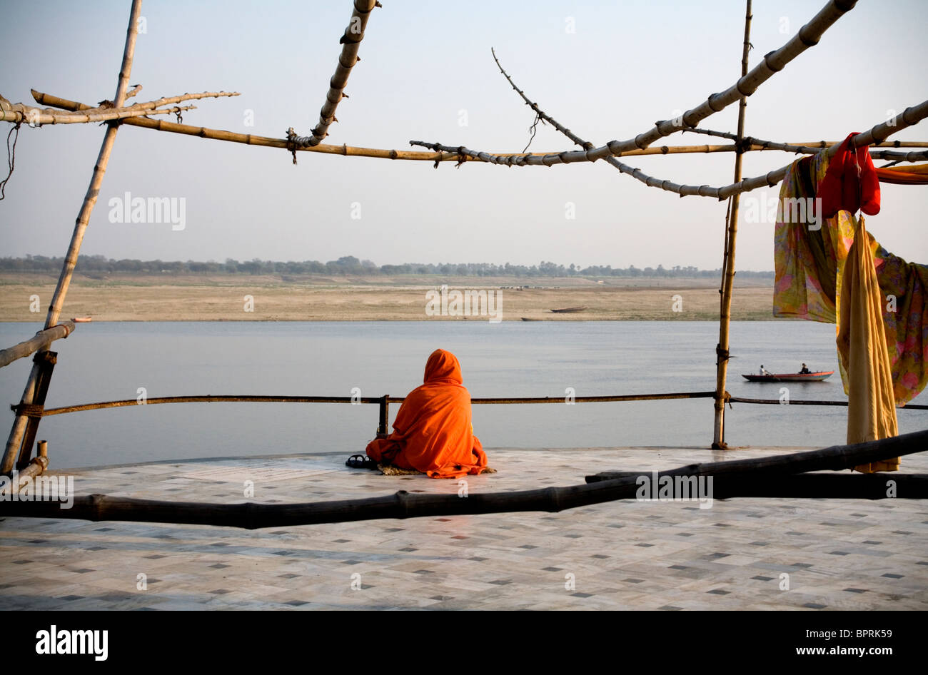 Holy man sitting on a terrace overlooking the River Ganges, Varanasi, Uttar Pradesh, India. Stock Photo