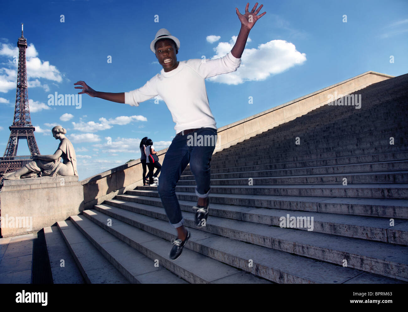 Man falling down the steps near the eiffel tower. Stock Photo