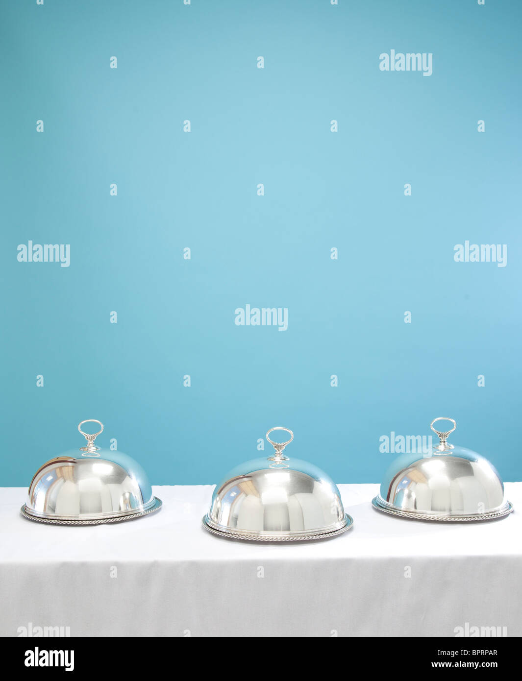 three silver serving dishes on table Stock Photo