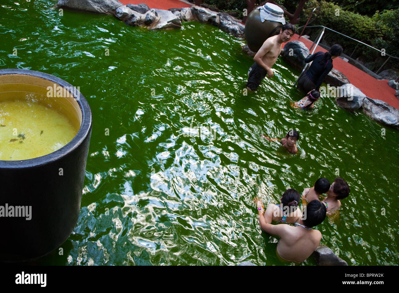 Green Tea Bath at Kowakien Yunessun - a hot springs spa resort and water amusement park located in the scenic surroundings of Ha Stock Photo
