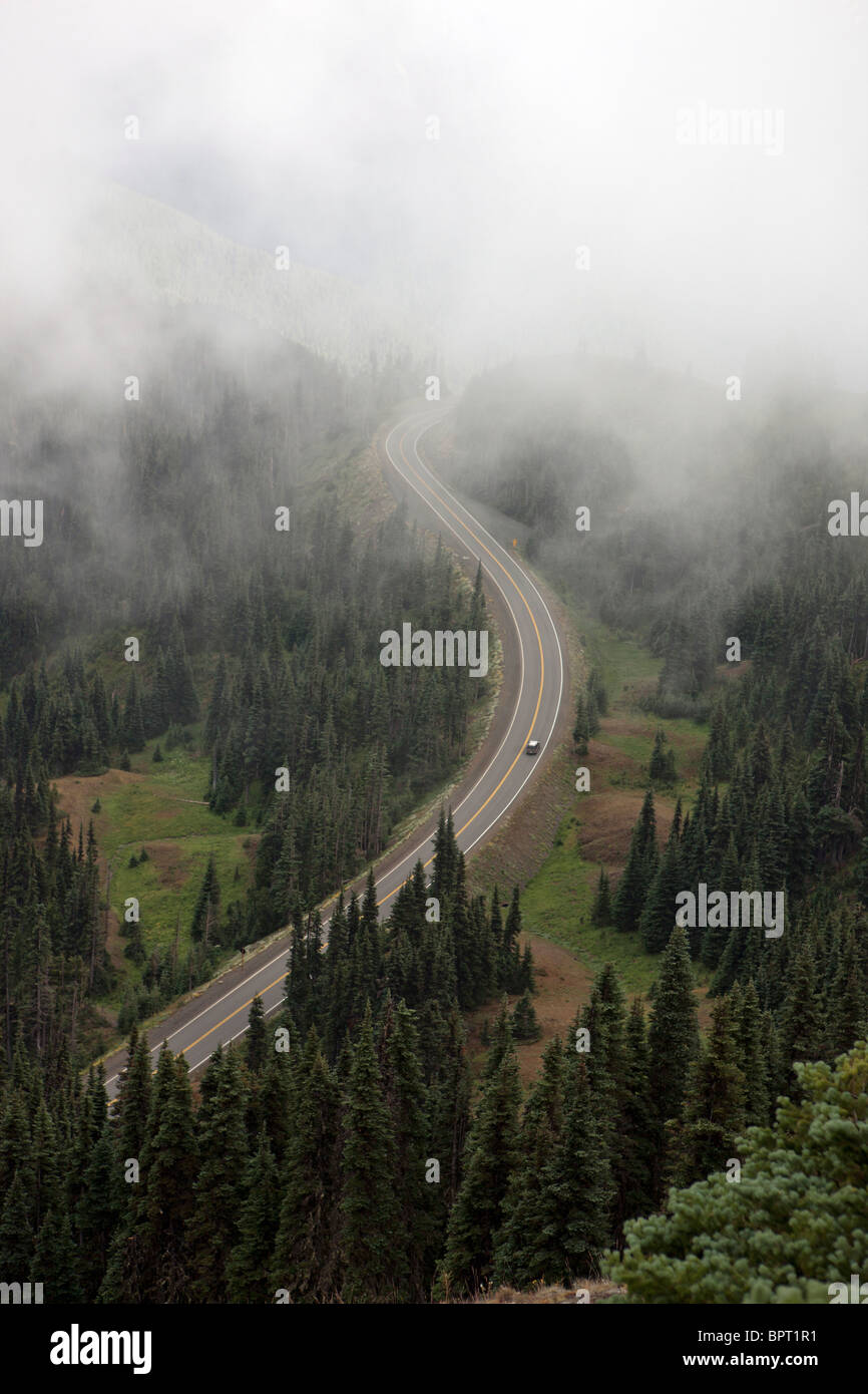 Car drives up winding mountain road to Hurricane Ridge through clouds, Olympic National Park, Washington Stock Photo
