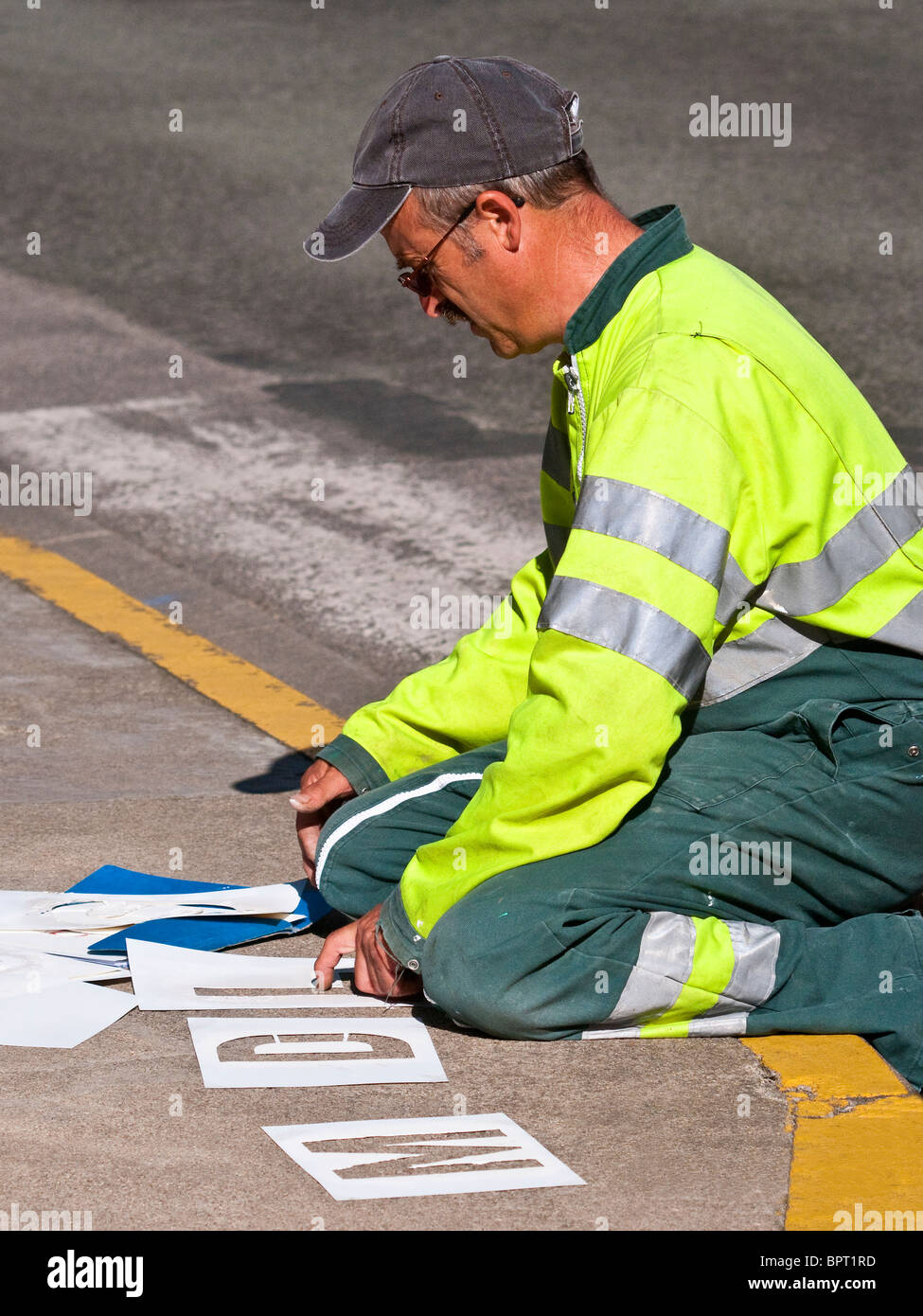Council worker sorting letter stencils for painting instructions on road - France. Stock Photo