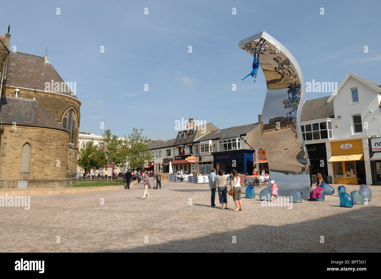 The regenerated St Johns Square in Blackpool Lancashire complete with cafe culture and public art under a blue sky sunny day. Stock Photo