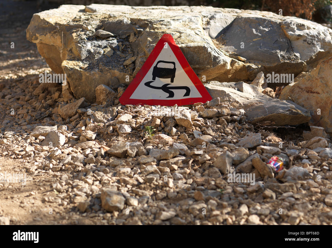 A traffic sign is warning against slip danger on a blocked road in Gibraltar, Aug 24, 2010. Stock Photo