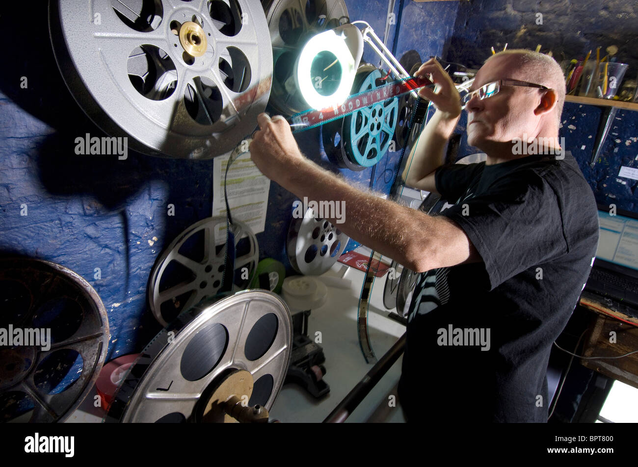 A projectionist in a cinema sets up a 35mm film. Stock Photo